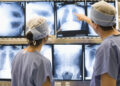 Two medical professionals review charts to a patients lungs.  brandcentralphotos